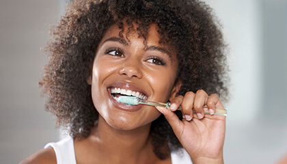 Female dental patient carefully brushing teeth