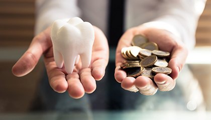 person holding a tooth and money in their hands