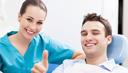 Male patient giving thumbs up in dental chair