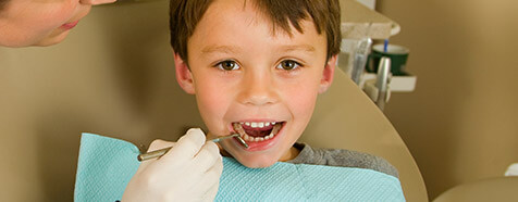 Young boy receiving treatment in dental chair