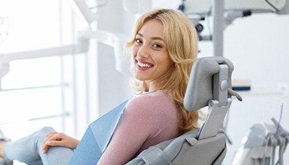 Woman smiling while sitting in treatment chair
