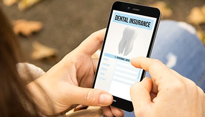 Woman looking at dental insurance on her phone