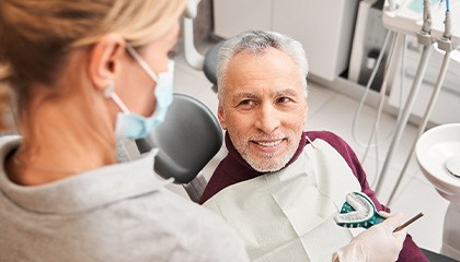 Dentist making manual impressions of man’s teeth