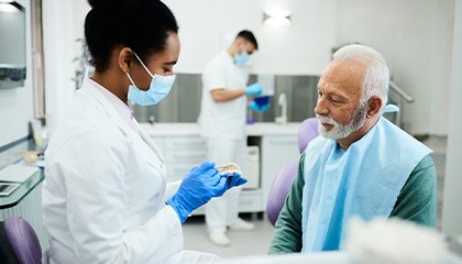 Dentist showing restoration to man in green shirt