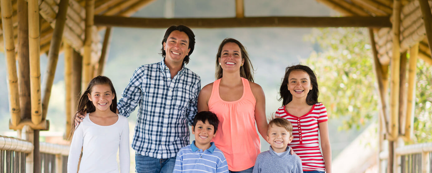 Mother and father with four smiling children outdoors