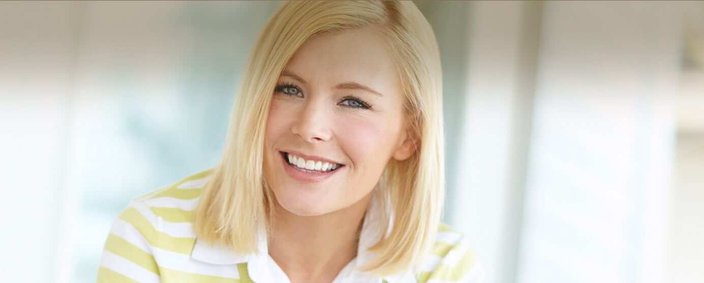 Smiling young woman in yellow and white striped shirt