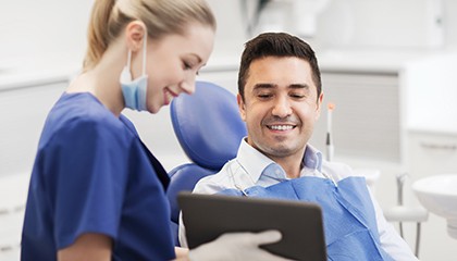 a dentist chatting with her patient about smile makeovers