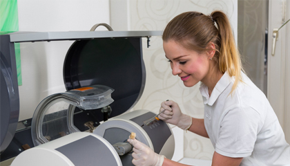 Dental assistant working with CEREC milling unit