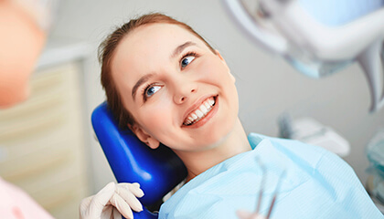 Relaxed female patient smiling in dental chair