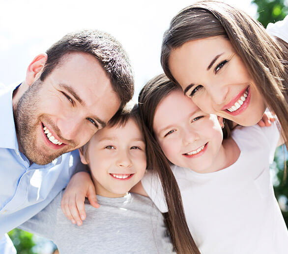 Family of four smiling outdoors