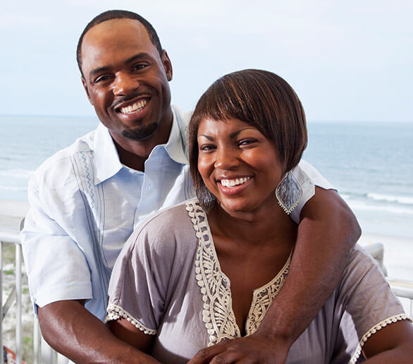 Happy man and woman grinning on the beach