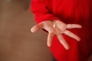 boy red shirt hand open tooth loss