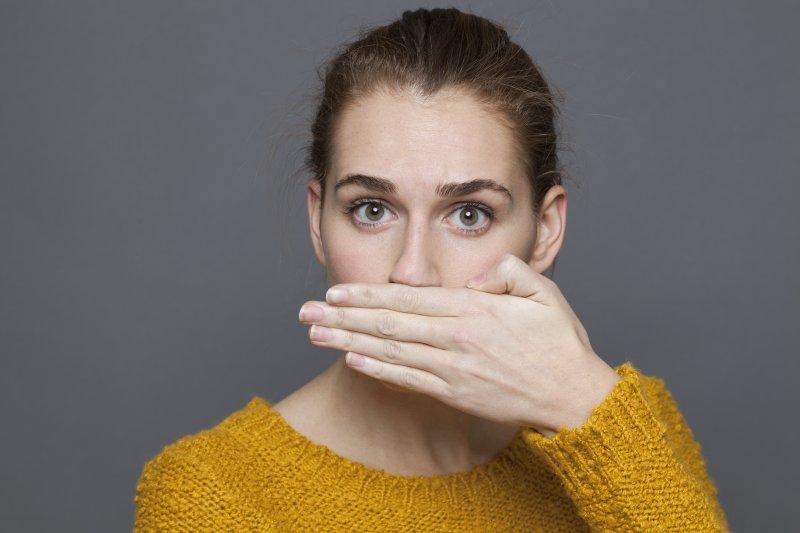 woman covering mouth bad breath