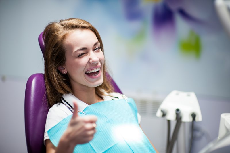 woman thumbs up dentist chair
