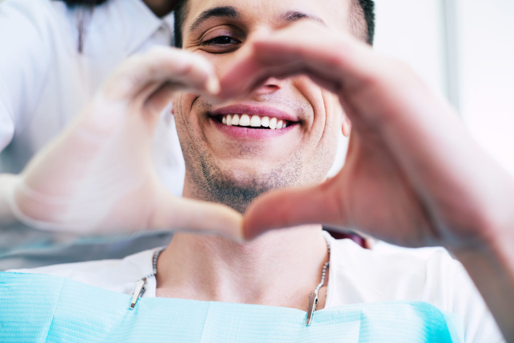 man smiling sitting in dentist chair