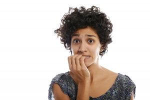 Concerned woman biting her fingernails