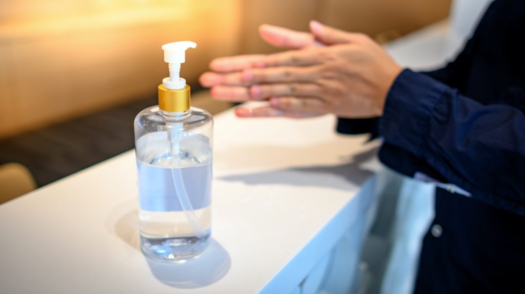 Person using hand sanitizer at dentist in Melbourne