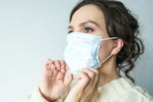 Woman putting on face mask before dentist in Melbourne.