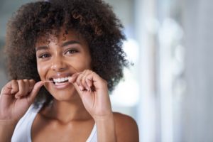 woman flossing to maintain healthy gums 