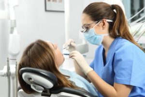 dentist in Melbourne, FL examining a patient’s mouth 