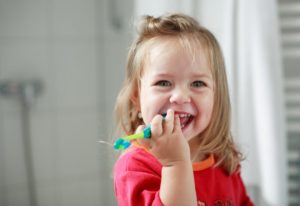 young girl brushing her teeth 
