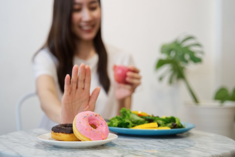 young woman rejecting donuts