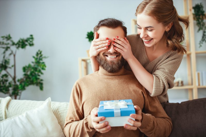person giving their partner Valentine’s Day dental gifts