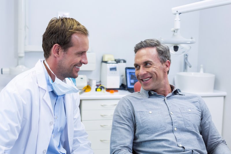 dentist talking about dental implant success with patient