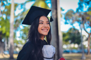 Young female student in black cap and gown