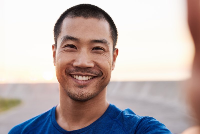 man smiling while standing outside 