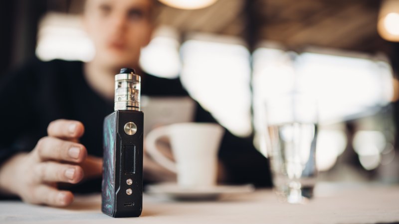 Man reaching for vape pen despite oral health risks