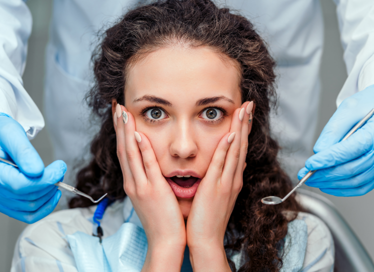 Patient in dental chair looking shocked